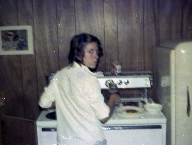 Person standing at a stove, possibly in the Hispanic House.