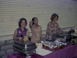People serving food in a buffet line