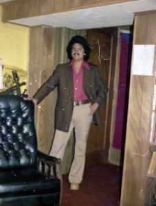 Person standing next to a chair, possibly in the Hispanic House