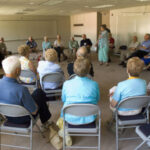 Members of the Class of 1951 seated in a circle at a forum in 2006