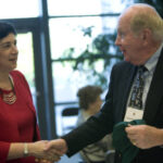 Member of the Class of 1951 shaking hands at a 2006 forum