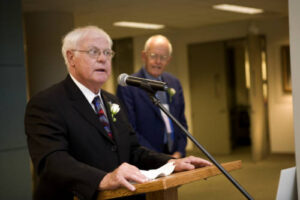 Member of the Class of 1951 speaking at a podium at a dinner in 2006