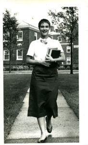 Woman with books walking on campus class of 1961