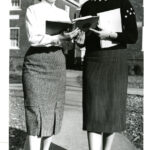 Two women with books walking on campus class of 1961