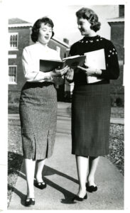 Two women with books walking on campus class of 1961