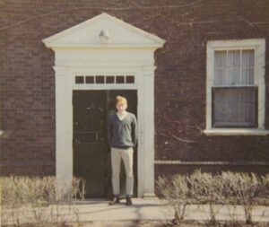 Photo of Don Hill standing in front of Kirk Hall