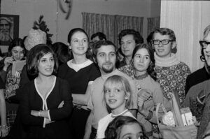 Group of students looking off-camera at the International Center, possibly in 1967; Feridoon Yusefzadeh with goatee
