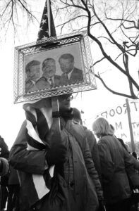 Protester carries portraits of JF Kennedy, ML King & RF Kennedy at March on Washington, November, 1969