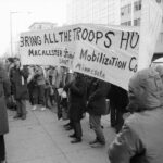 Students with a huge banner at the March on Washington in November 1969; the part of the banner that is visible reads, "Bring the Troops Home; Macalester Student Mobilization Committee; Saint Paul, Minnesota"