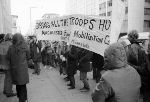 Students with a huge banner at the March on Washington in November 1969; the part of the banner that is visible reads, "Bring the Troops Home; Macalester Student Mobilization Committee; Saint Paul, Minnesota"