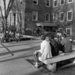 Small groups of students hanging out on benches outside of the Student Union, Fall 1966