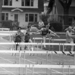 Runners jumping hurdles at a MIAC track meet in Spring 1969