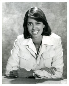 Class portrait of Connie Hicks seated with her arms folded
