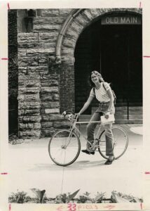 Mary on a bike in front of Old Main