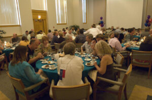 Photo of alums gathered around tables eating dinner