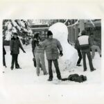 Students building a snowman on campus in winter in 1978