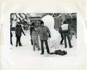 Students building a snowman on campus in winter in 1978