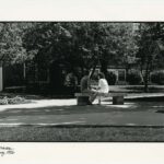 Two students on a bench in front of Dayton Hall in Spring 1986