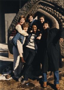 Group photo of students outside in front of a sculpture on campus
