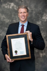 Photo of Paul Rausenbush with Alumni Award in 2011