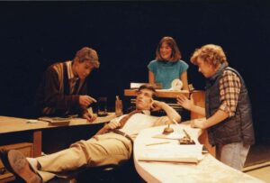 Four performers on stage in The Hot L Baltimore in 1987; one is reclining while surrounded by the other three