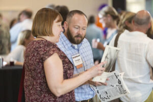 Two people looking at a publication at Reunion 2016