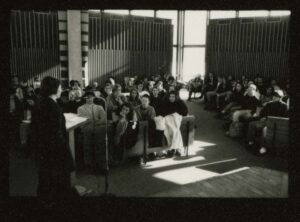 Photo of a teach-in in the Chapel on 2/15/1991; a speaker is at the podium and microphone while students in the pews listen