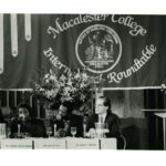 Four panelists sitting in front of a large banner at the International Roundtable 1995