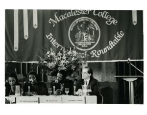 Four panelists sitting in front of a large banner at the International Roundtable 1995