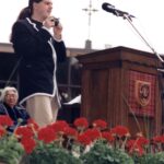 Student with a camera at the podium at Commencement 1996