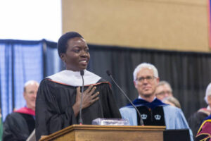 Danai at the podium giving the Commencement address with President Rosenberg looking on