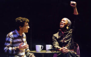 Two characters from the 2007 production Angels in America having tea and talking