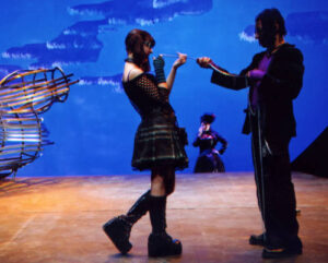 Two characters from the production of Ophelias, holding onto a string and looking at each other