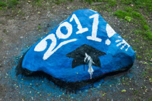 The rock is painted to celebrate the class of 2011. It is blue with white numbers saying "2011" and a cap below the year.