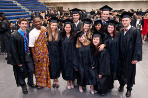 A group of students in their caps and gowns posing after commencement