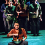 Scene: performer sitting on floor stirring a bowl