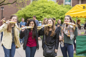 Students posing, eating corn on the cob